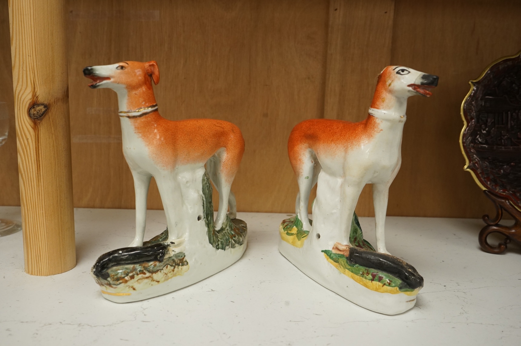 A pair of Staffordshire whippets, 19th century, one damaged, 19cm wide